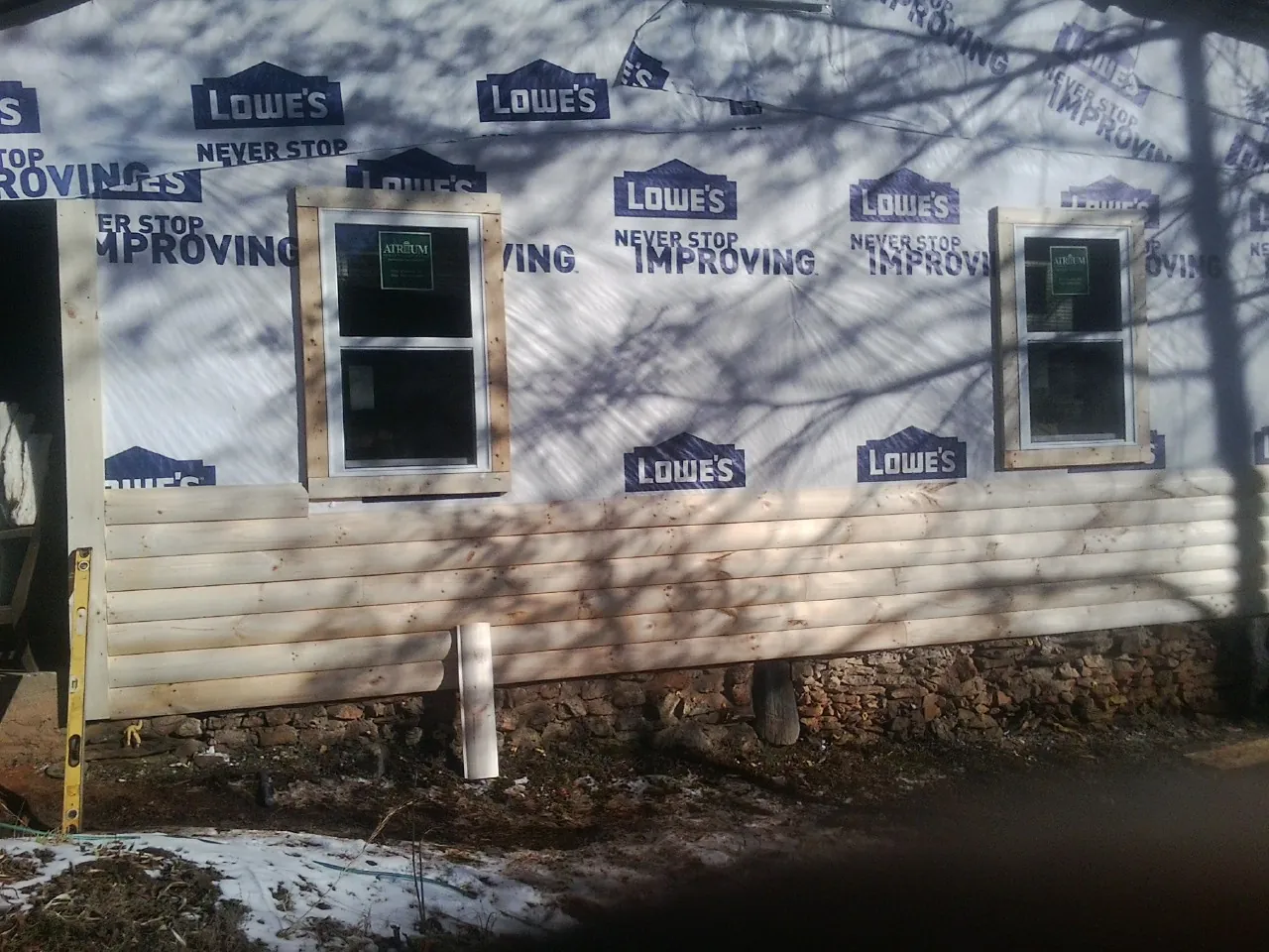 House wrap and new log siding going up on an exterior wall in Sherwood