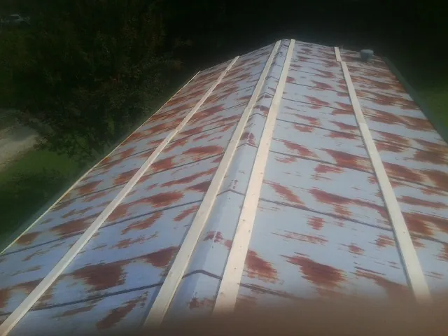 Rusted metal roof panels with new wood purlins before replacement — Storm Damage Roof Repair in Sherwood by Roofing Brothers
